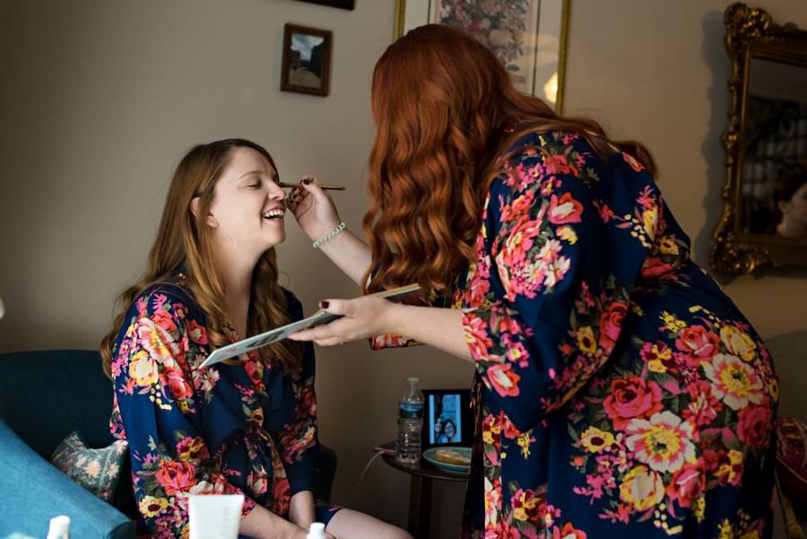 Bridesmaids doing each others makeup before the wedding.
